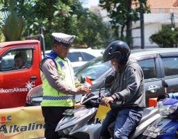 Satlantas Polrestabes Surabaya Bagikan Bendera Merah Putih ke Pengguna Jalan