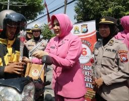 Sapa Warga di Hari Jadi ke -76, Polwan Polrestabes Surabaya Turun Jalan Berbagi Helm dan Bunga