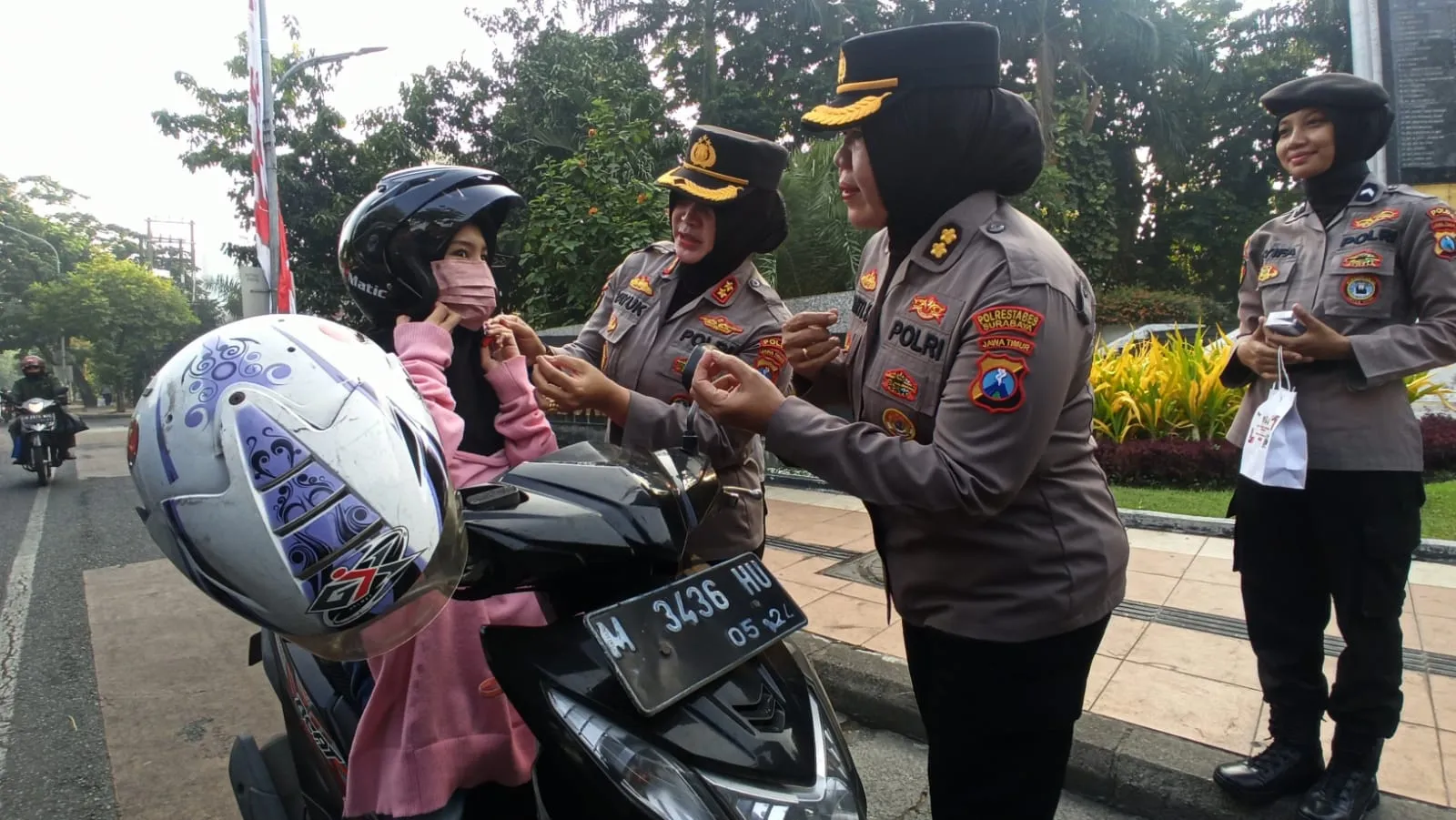 Peduli Keselamatan Lalu – lintas, Polwan Polda Jatim Gaturlalin dan Berbagi Helm Gratis