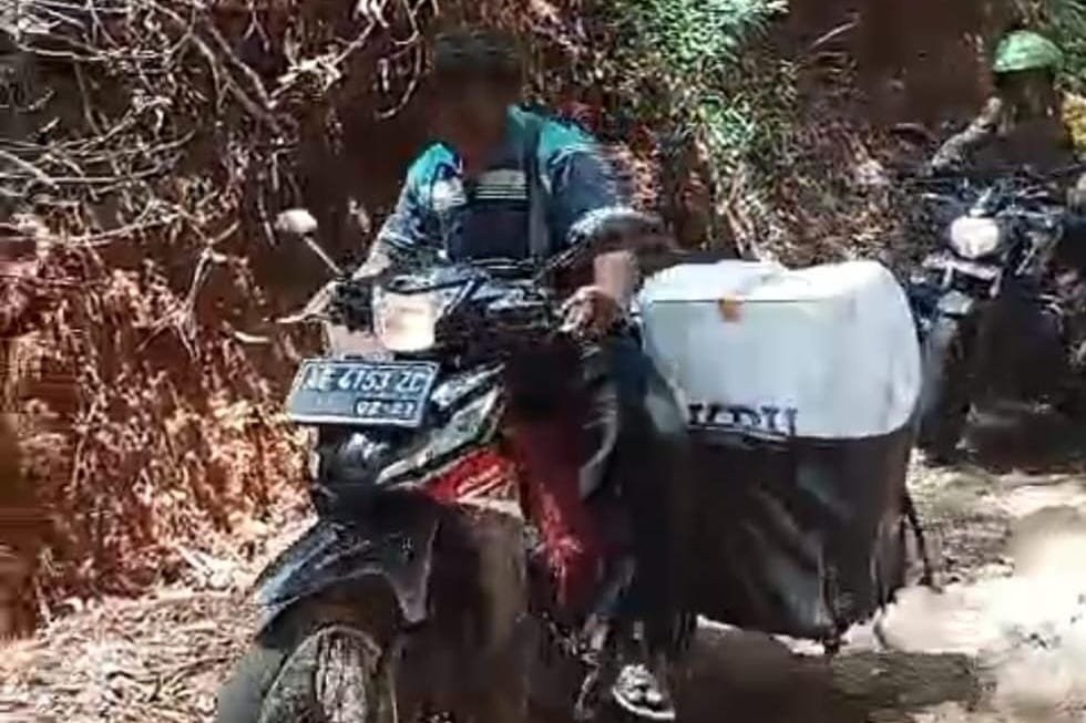Bripka Deni Widiantoro, anggota Polsek Arjosari, Polres Pacitan, bersama TNI dan Linmas menempuh medan terjal untuk mengawal distribusi logistik pemilu ke tempat pemungutan suara (TPS) di Dusun Ngasem dan Dusun Jati, Desa Kedungbendo, Kecamatan Arjosari.