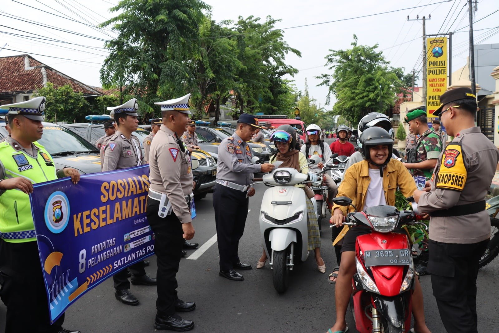 Polres Pamekasan, Madura membagikan brosur sosialisasi operasi Keselamatan Semeru 2024 terhadap pengendara yang melintas di jalan raya.